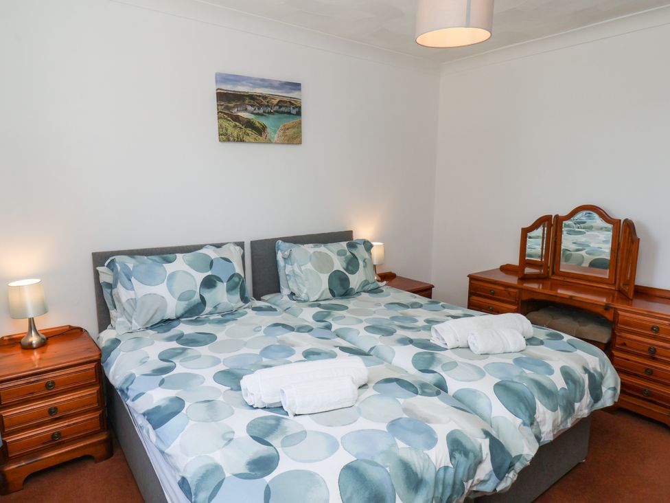 A bedroom with a double bed and dressing table at Castelian in Flamborough