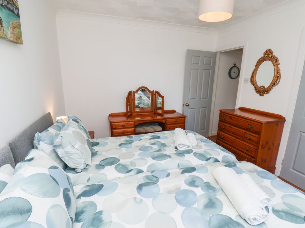 A bedroom with a bed and dresser at Castelian in Flamborough