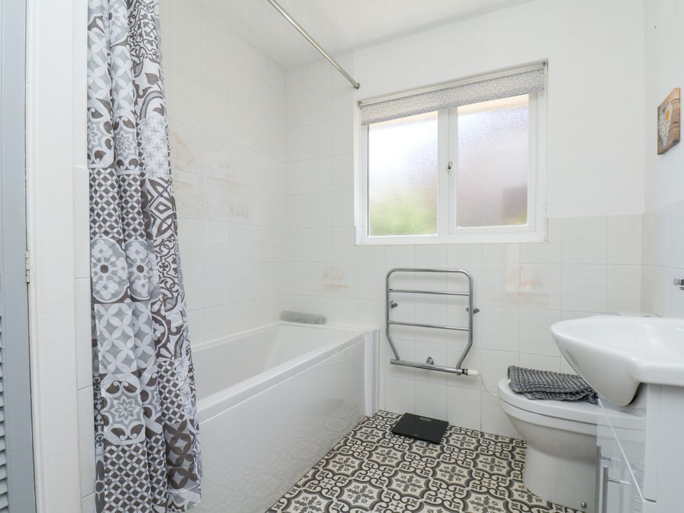 A bathroom with a bathtub, toilet, and sink at Castelian in Flamborough