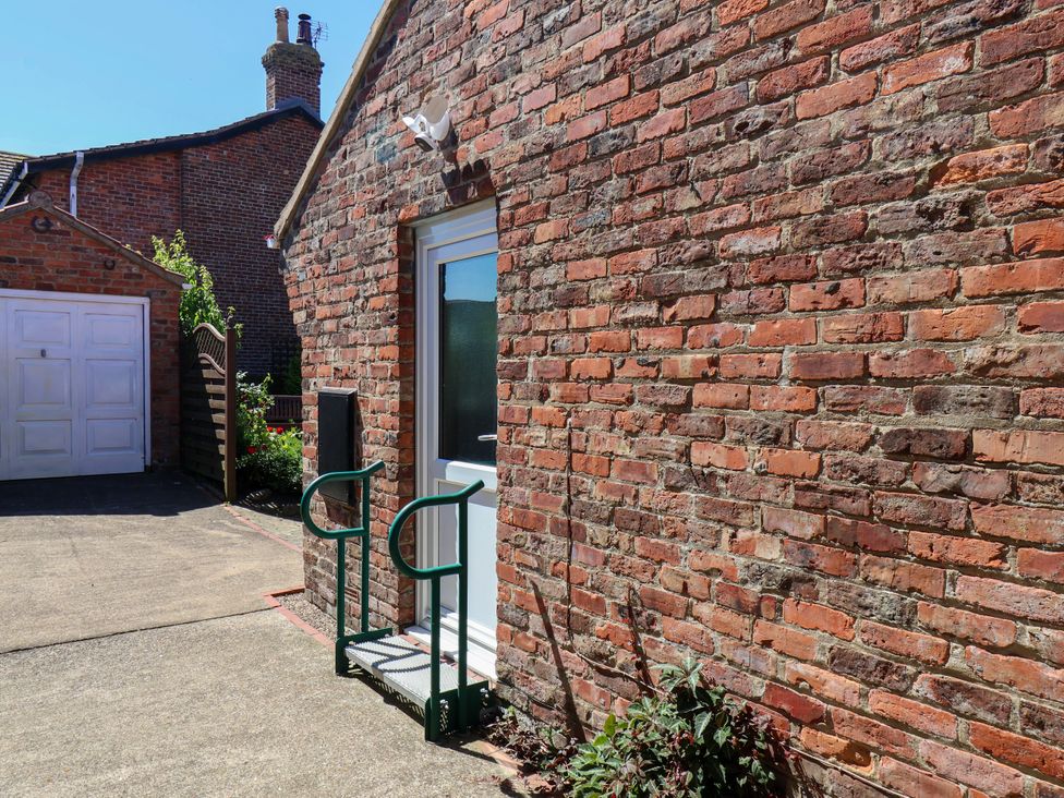 An outdoor area with a brick wall and a door at Castelian in Flamborough