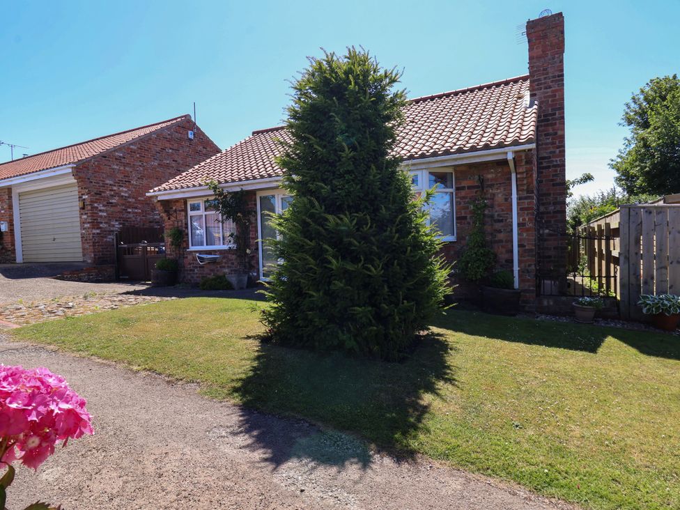 A house with a bush and garage at Castelian in Flamborough