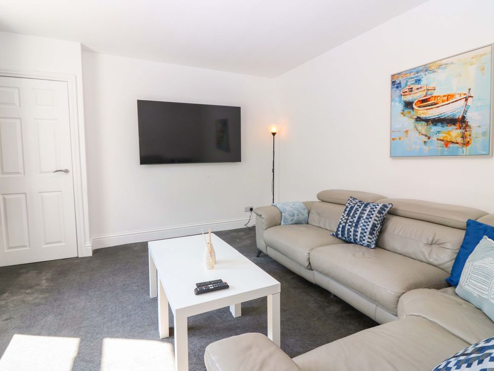 A living room with a sofa and a television at No.9 North St in Fraserborough