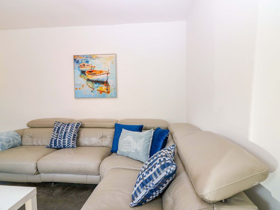 A living room with a sofa and a painting at No.9 North St in Fraserborough