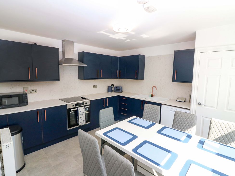 A kitchen with blue cabinets and a dining table at No.9 North St, Fraserborough