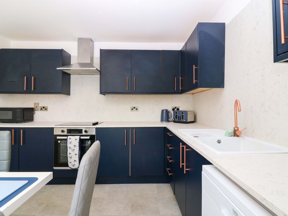A kitchen with blue cabinets and white countertop at No.9 North St in Fraserborough