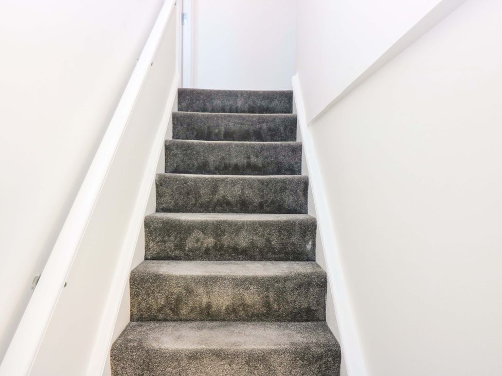 A staircase with carpet and a railing at No.9 North St Fraserborough