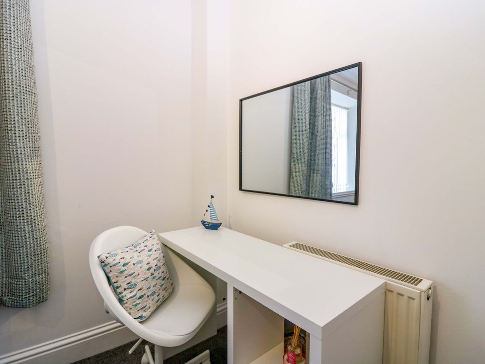 A desk with a chair and a mirror in a home office at No.9 North St, Fraserborough