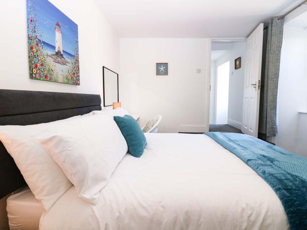 A bedroom with a bed and artwork at No.9 North St, Fraserborough