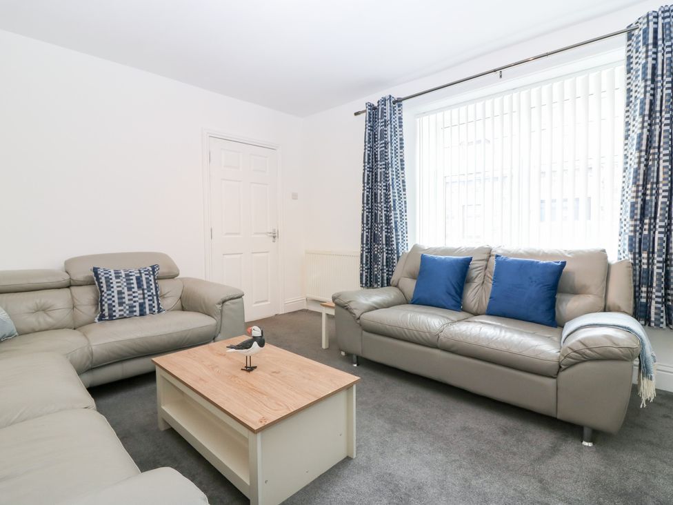 A living room with leather sofas and a coffee table at No.9 North St Fraserburgh