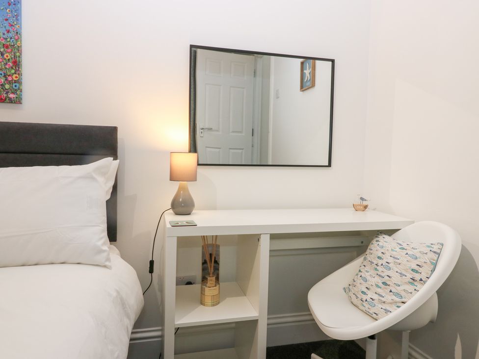 A bedroom with a bed and a desk beside a chair at No.9 North St Fraserburgh