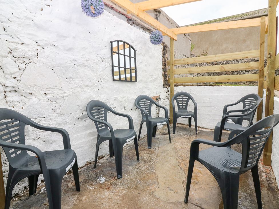 An outdoor seating area with plastic chairs and a mirror at No.9 North St Fraserburgh