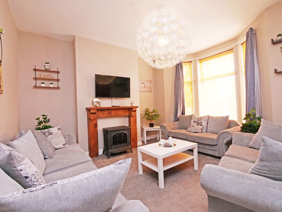 A living room with a television and a fireplace at Ashville Grange in Scarborough
