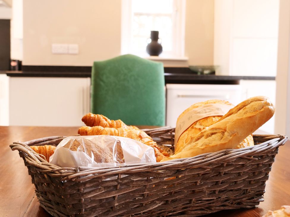 A basket of bread and croissants in a kitchen at Ashville Grange in Scarborough