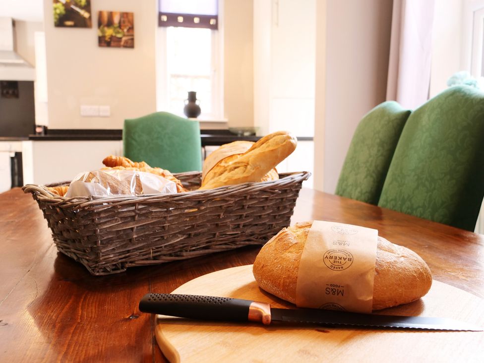 A kitchen with bread and a knife on a table at Ashville Grange in Scarborough
