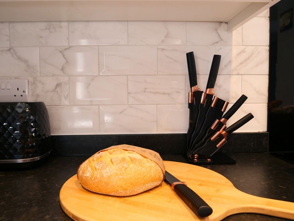 A kitchen with a cutting board and bread at Ashville Grange in Scarborough