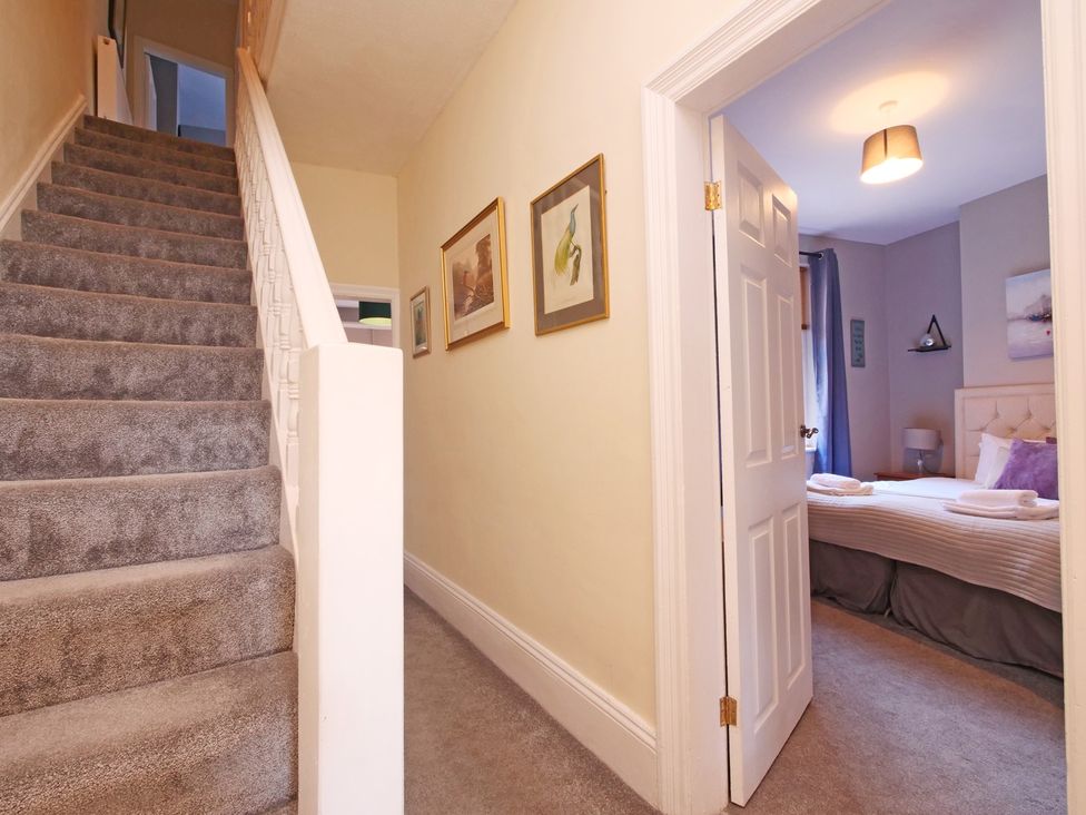A hallway with a staircase leading to a bedroom at Ashville Grange in Scarborough