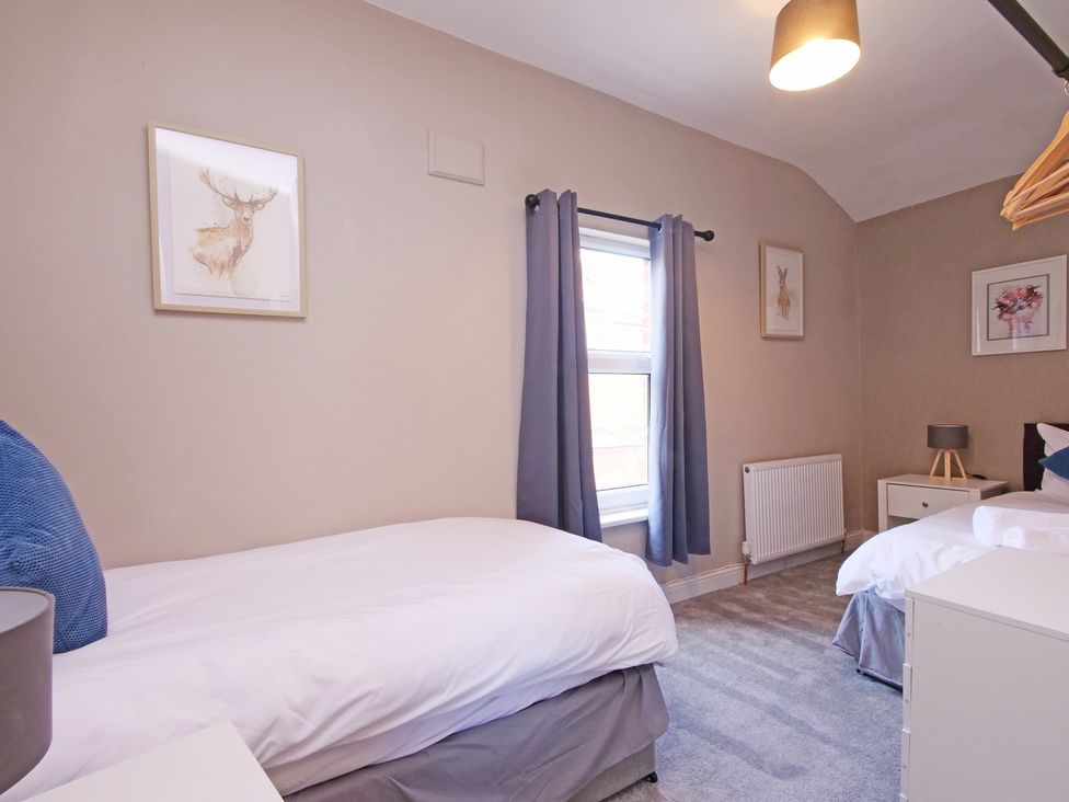 A bedroom with two beds and a window at Ashville Grange Scarborough