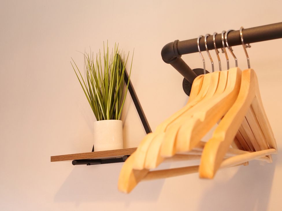 A shelf with plant and wooden hangers in a closet at Ashville Grange in Scarborough