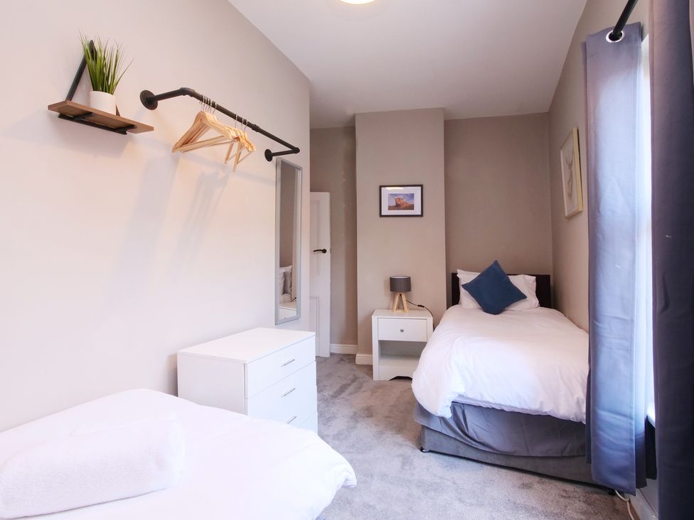 A bedroom with two beds and a nightstand at Ashville Grange in Scarborough