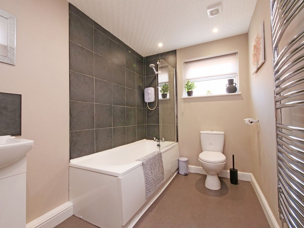 A bathroom with a bathtub, toilet, and sink at Ashville Grange in Scarborough