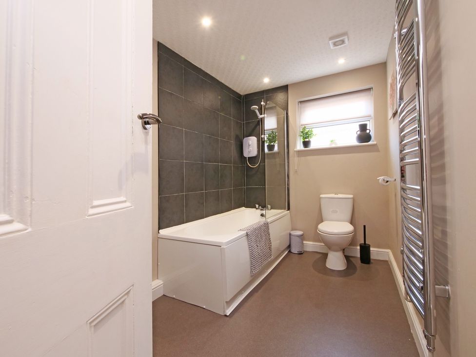 A bathroom with a bathtub and toilet at Ashville Grange in Scarborough