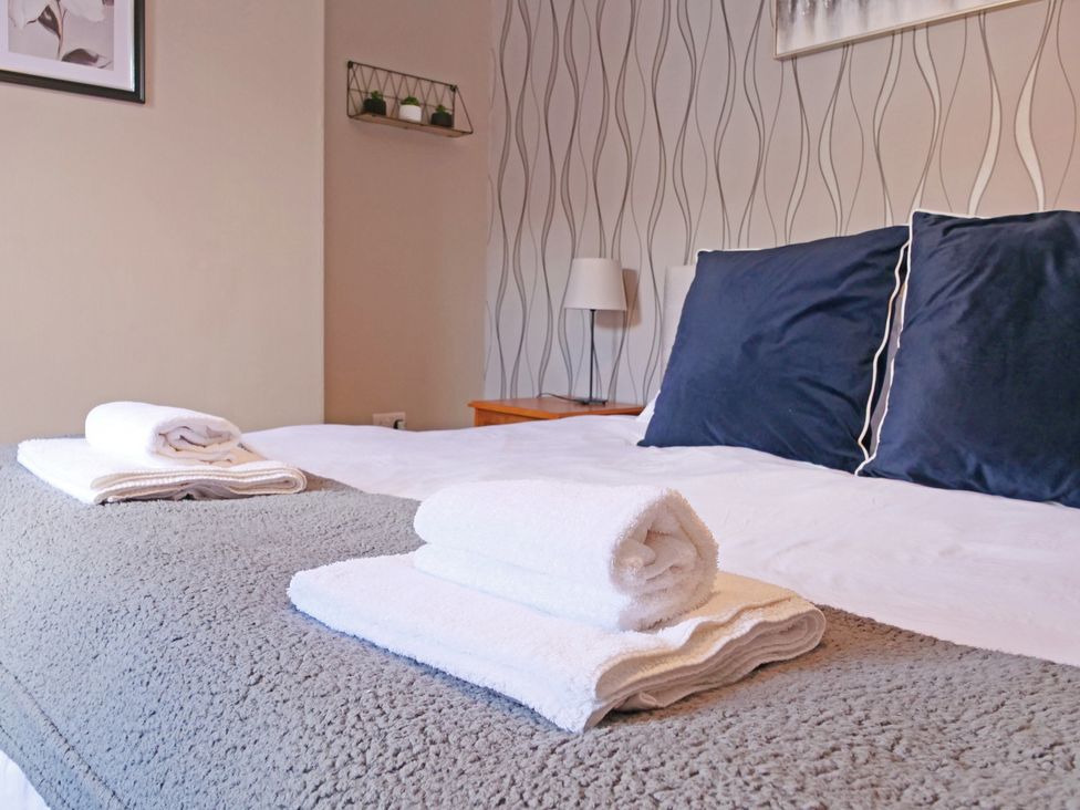 A bedroom with a bed and towels at Ashville Grange in Scarborough