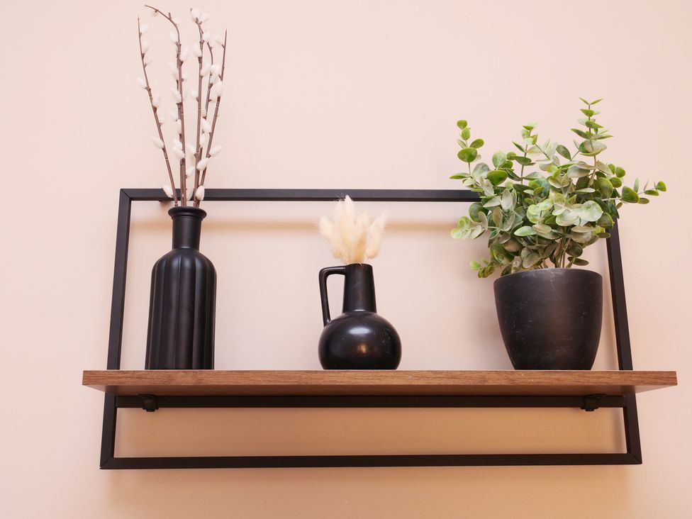A shelf with decorative vases and plants at Ashville Grange in Scarborough
