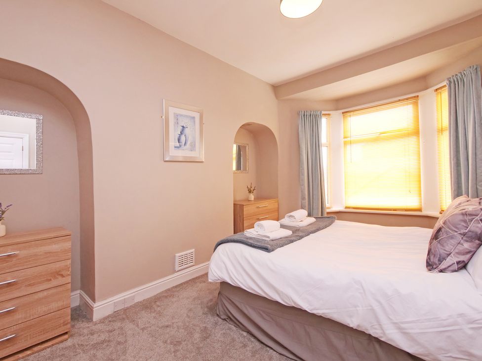 A bedroom with a bed and dresser at Ashville Grange in Scarborough