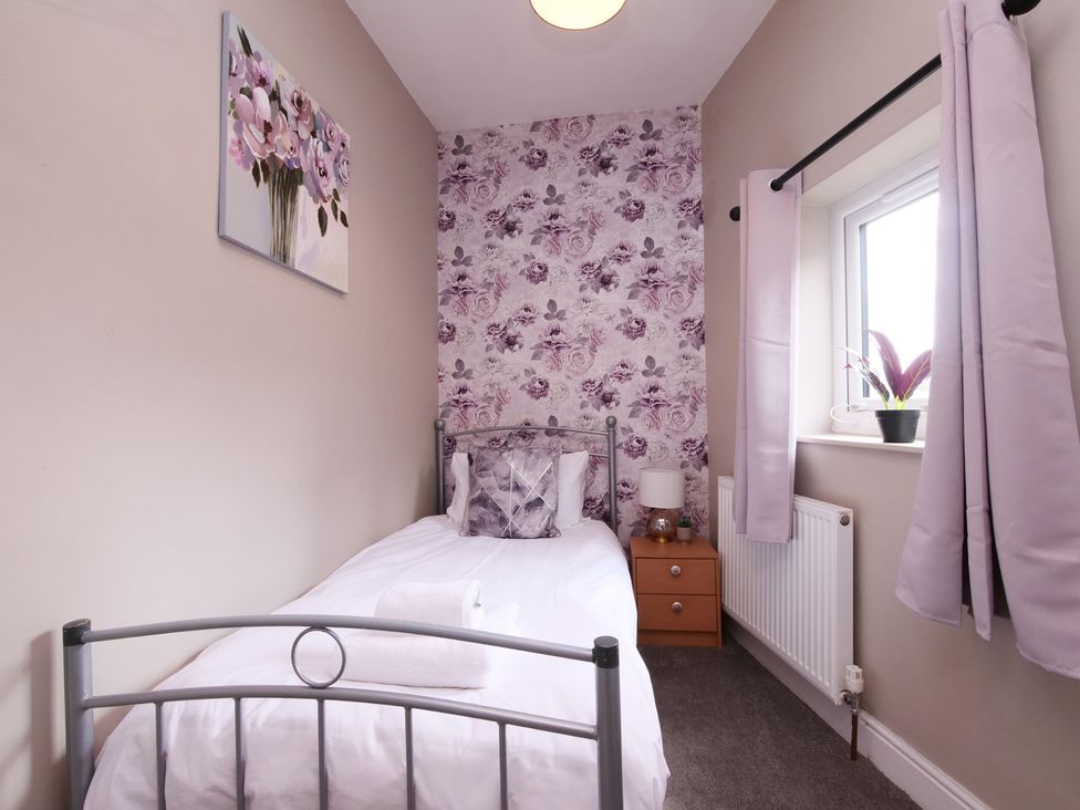 A bedroom with a single bed and wall art at Ashville Grange in Scarborough