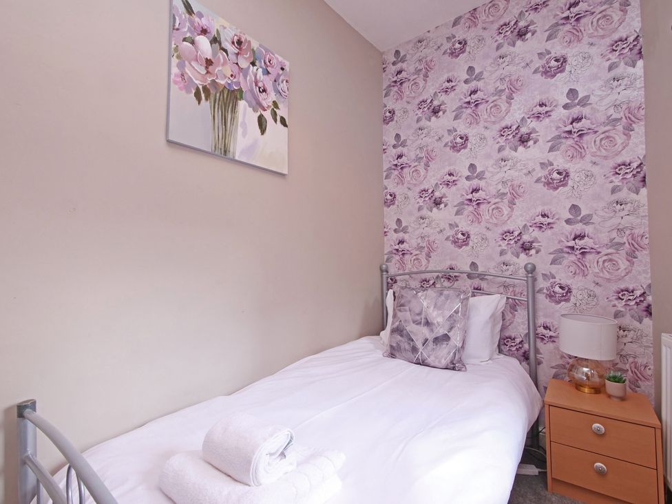 A bedroom with a single bed and a bedside table at Ashville Grange in Scarborough
