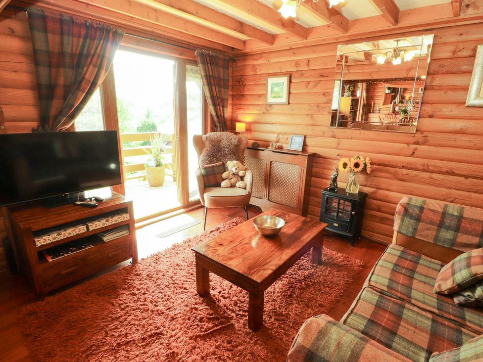 A living room with a sofa and television at Thistle Dubh (