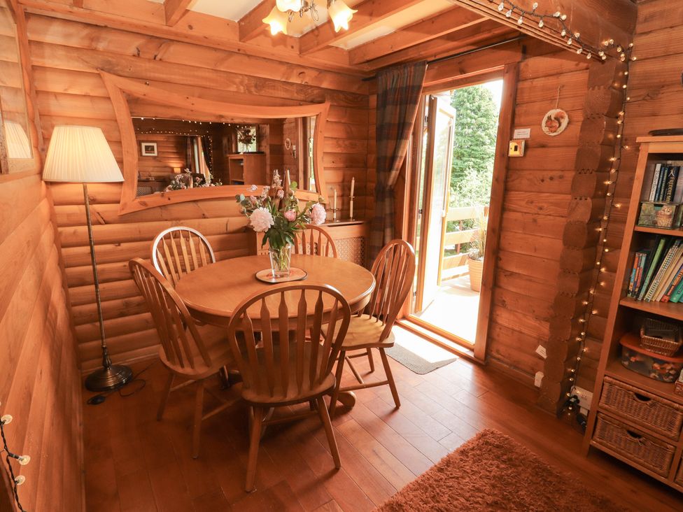 A dining room with a table and chairs at Thistle Dubh ('Doo') Sandyhills