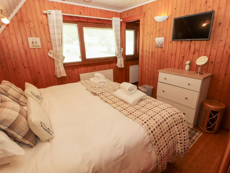 A bedroom with a bed and dresser at Thistle Dubh ('Doo') Sandyhills