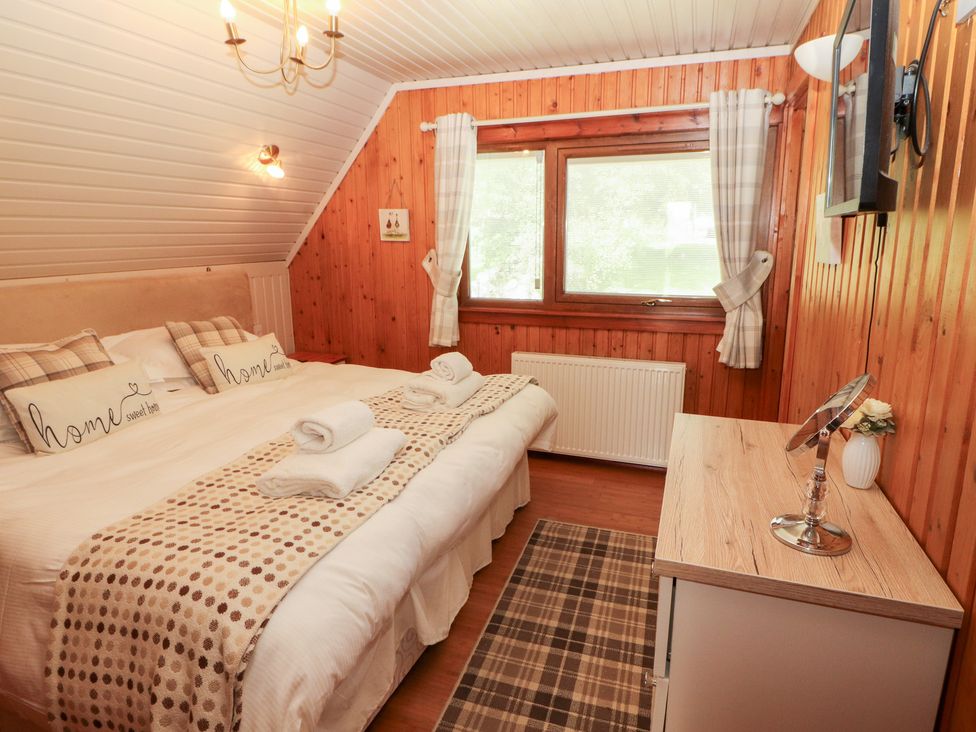 A bedroom with a bed and nightstand at Thistle Dubh ('Doo') Sandyhills