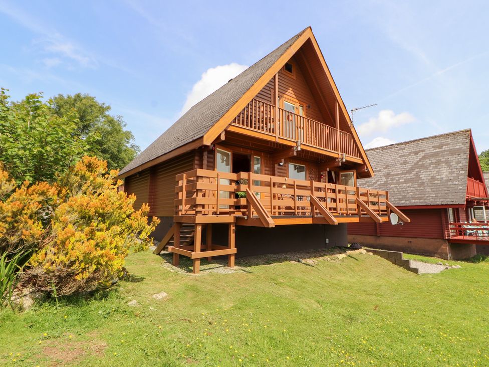 A wooden house with balconies and a garden at Thistle Dubh (