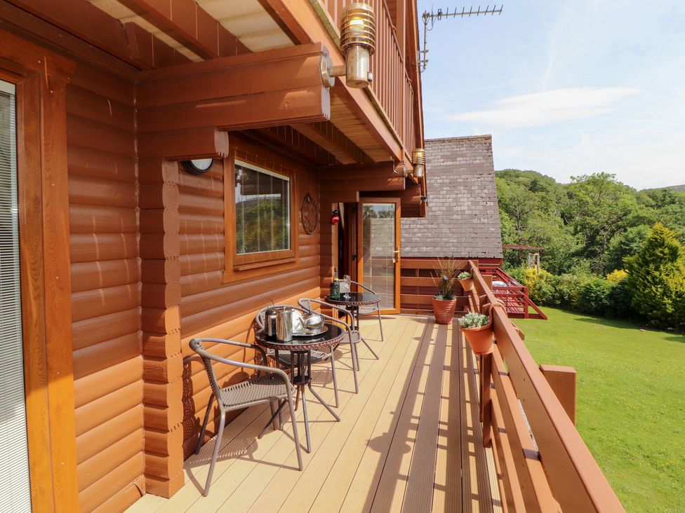 A balcony with a table and chairs at Thistle Dubh ('Doo') Sandyhills