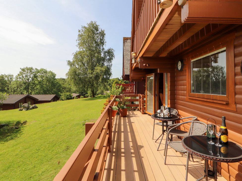A balcony with a table and chairs at Thistle Dubh ('Doo') Sandyhills