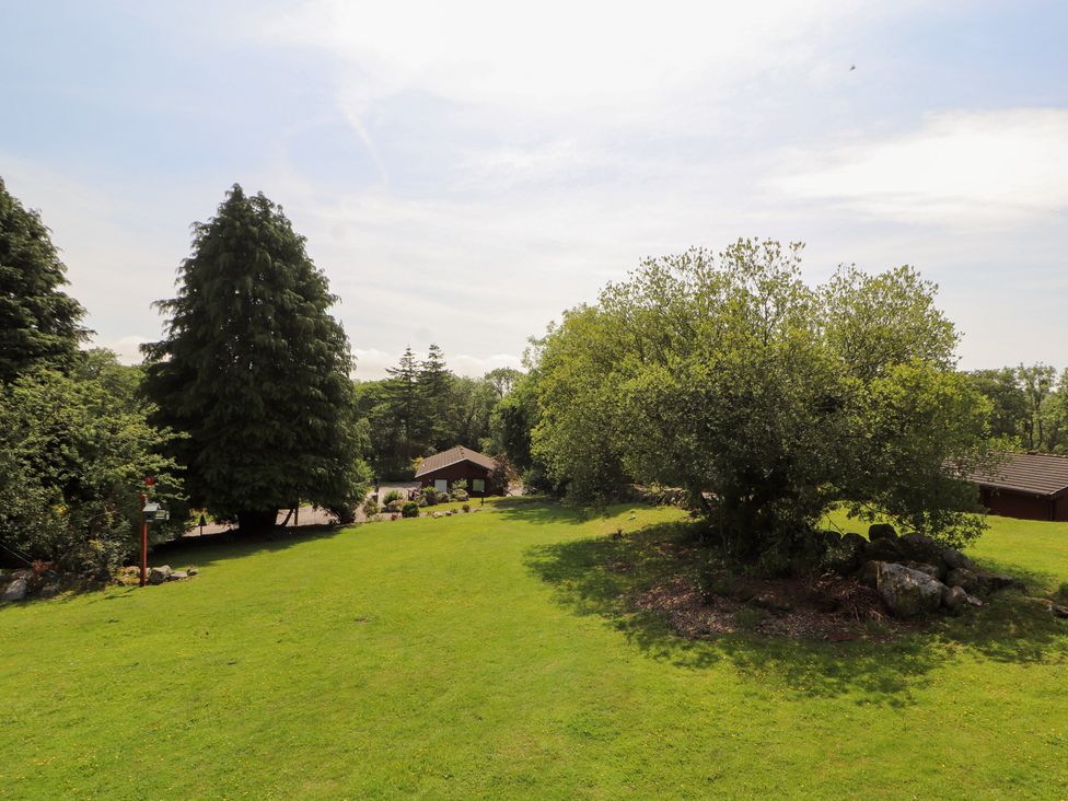 A garden area with trees and a house at Thistle Dubh ('Doo') Sandyhills