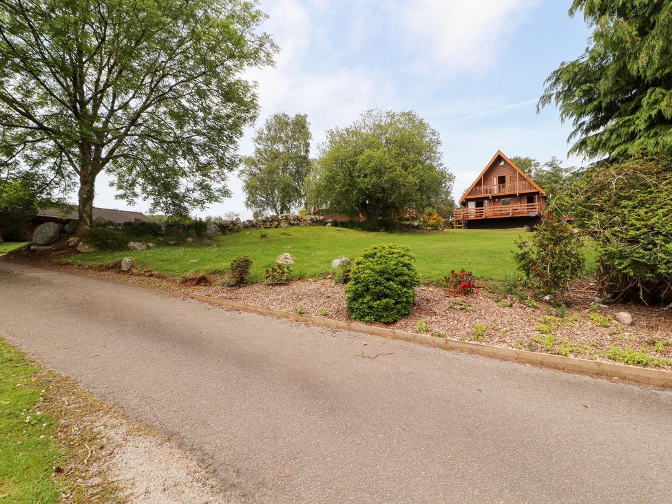 A house surrounded by grass and trees at Thistle Dubh ('Doo') Sandyhills