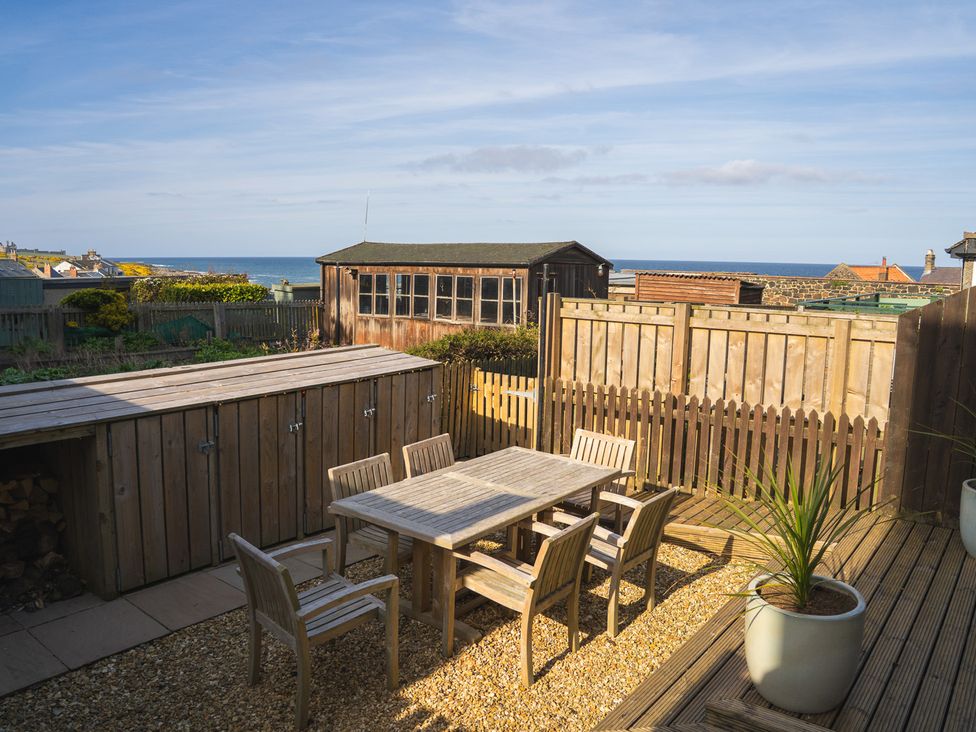 A garden with a table and chairs at Craster Reach in Craster