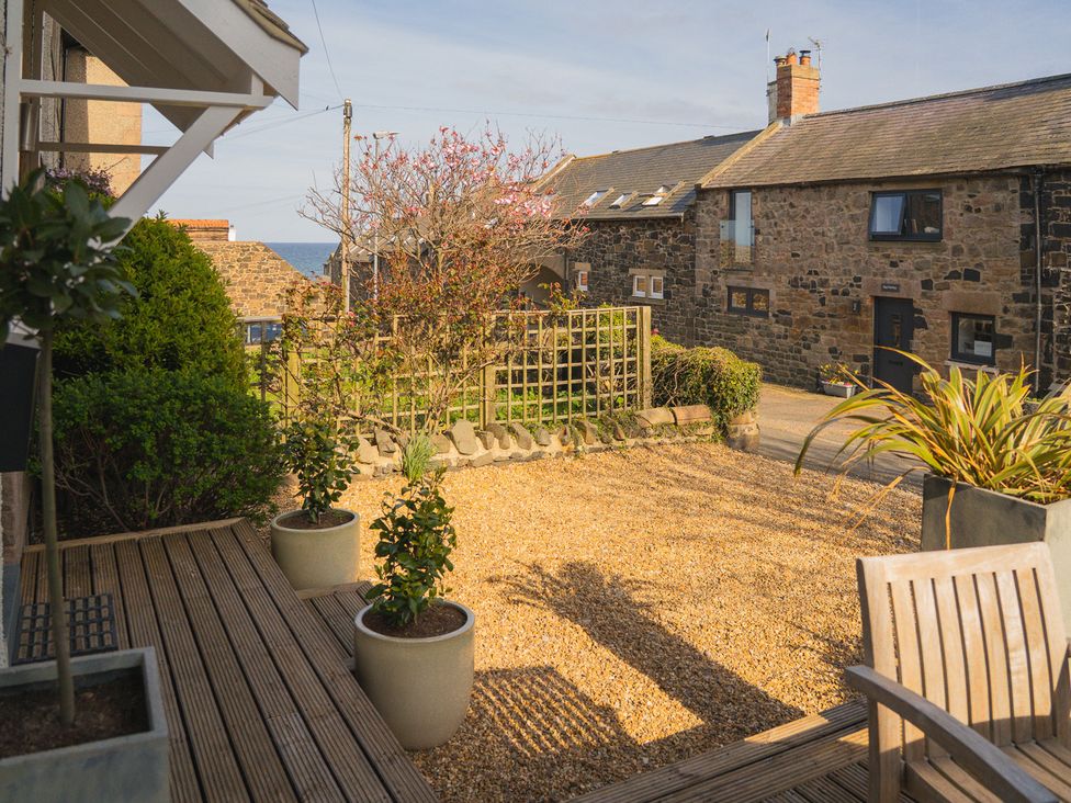 A garden with gravel and planters at Craster Reach in Craster