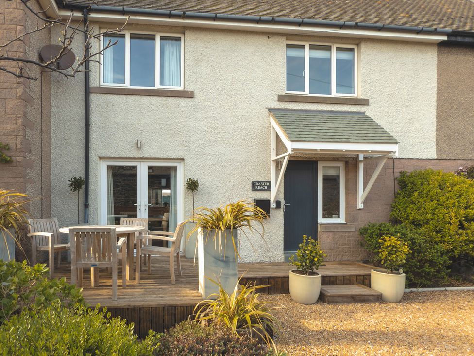 An outdoor view of a house with a table and chairs at Craster Reach in Craster