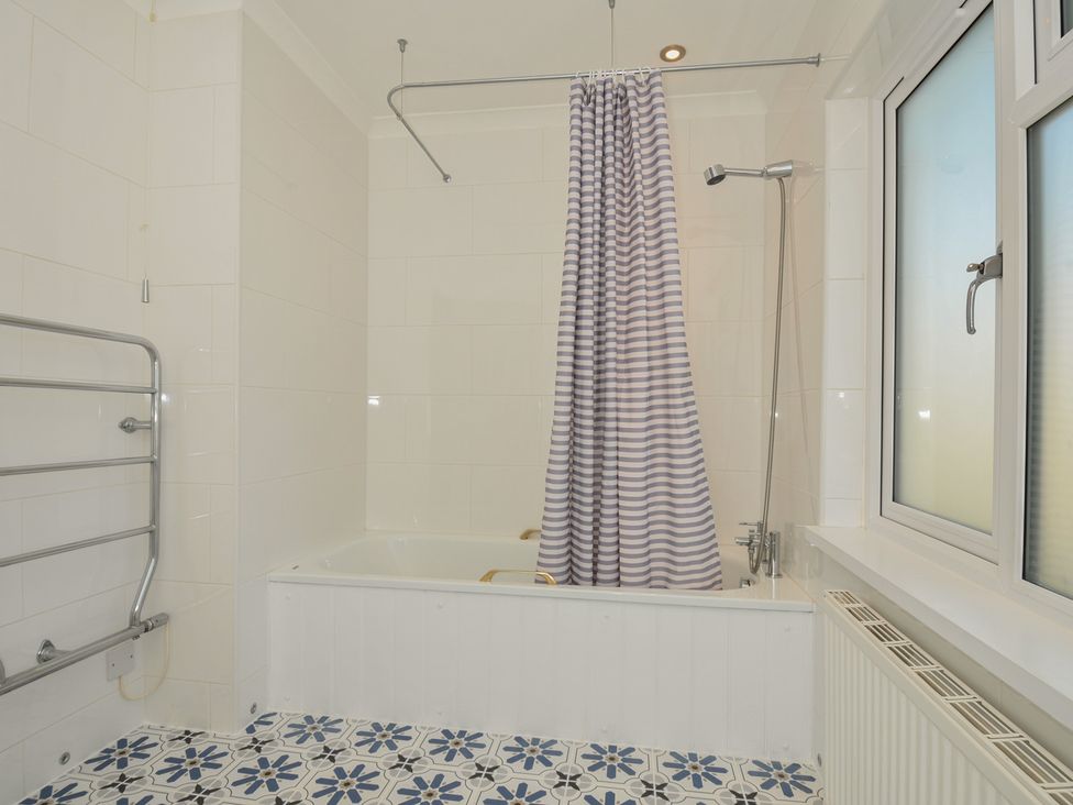A bathroom with a bathtub and a shower at 6 Trelawney Court Rock