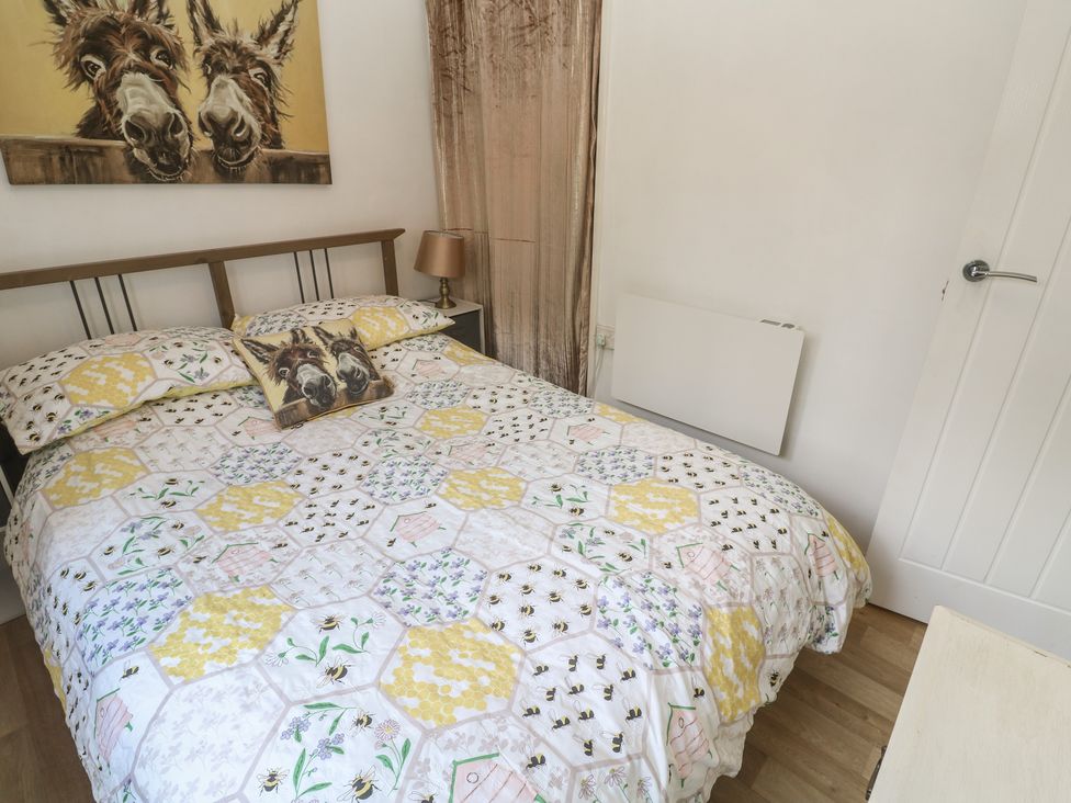 A bedroom with a bed and wall art at Tolroy Manor Holiday Park St Erth Praze near Hayle