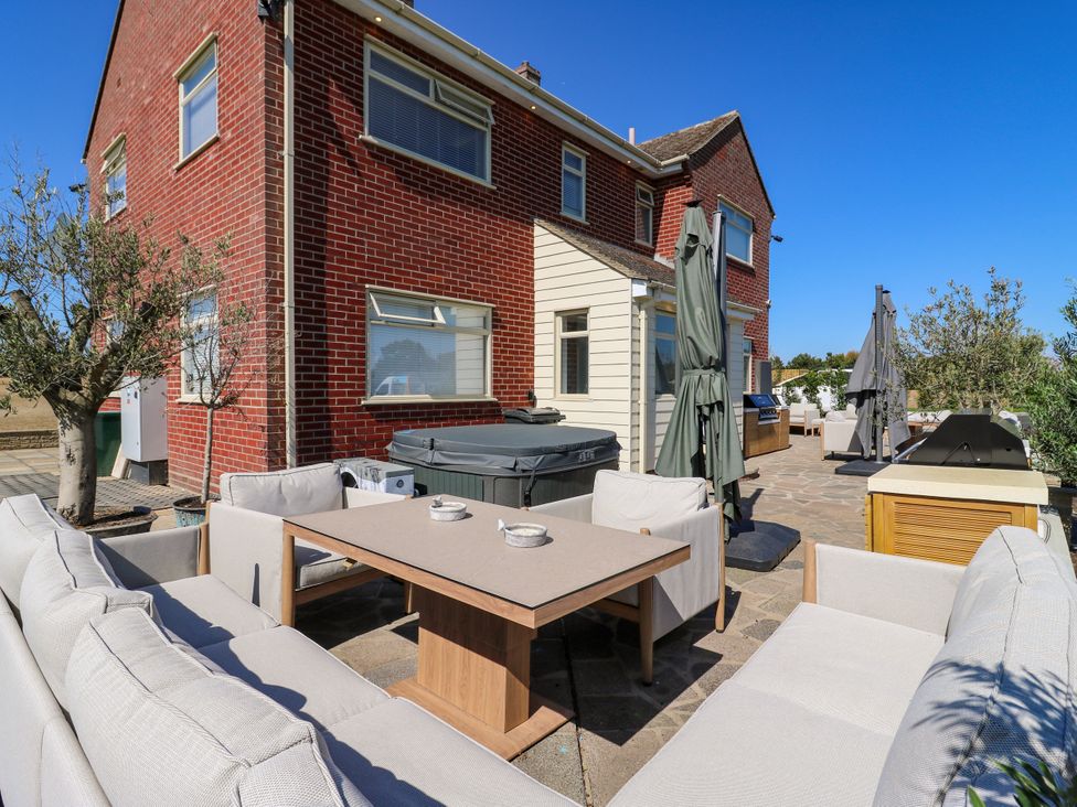 An outdoor area with furniture and a barbecue grill at The Farmhouse in St. Osyth