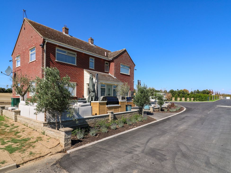 A house with outdoor seating and landscaping at The Farmhouse in St. Osyth