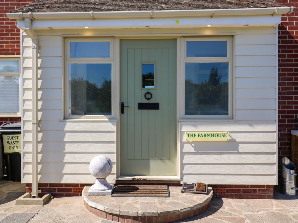 An entrance with a green door and sign at The Farmhouse in St. Osyth