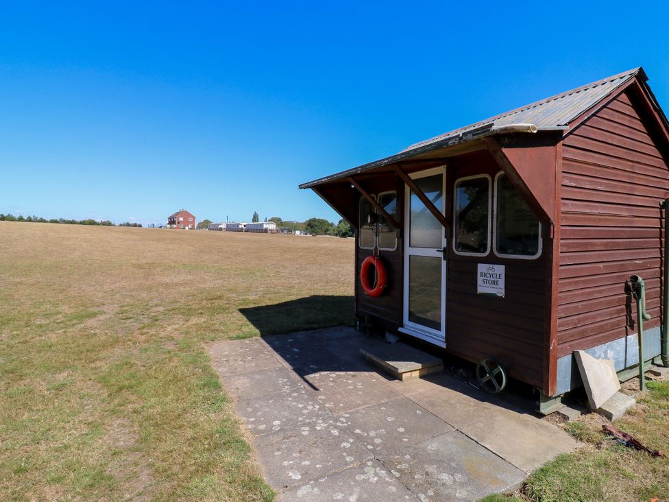 A bicycle store with a door and windows at The Farmhouse in St. Osyth