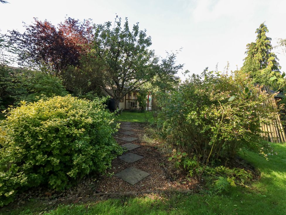 A garden with trees and a pathway at Little Timbers in Ringwood