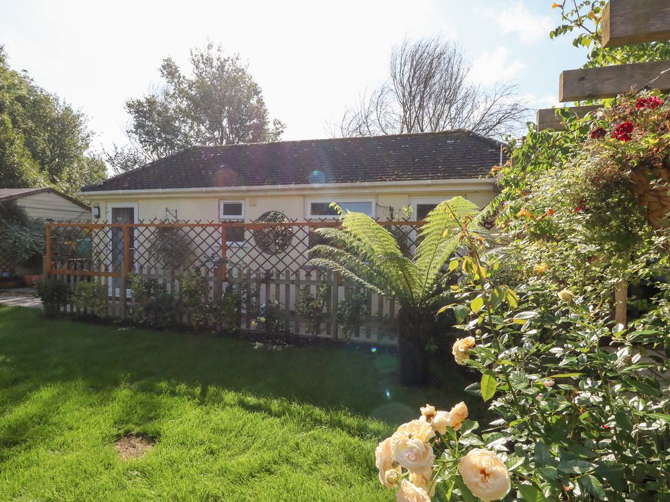 A garden with a building and plants at Little Timbers in Ringwood